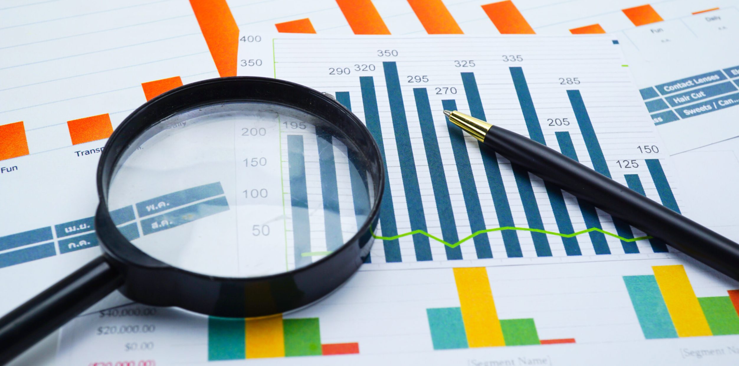 Magnifying glass on charts graphs spreadsheet paper. Financial development, Banking Account, Statistics, Investment Analytic research data economy, Stock exchange trading, Business office company meeting concept.